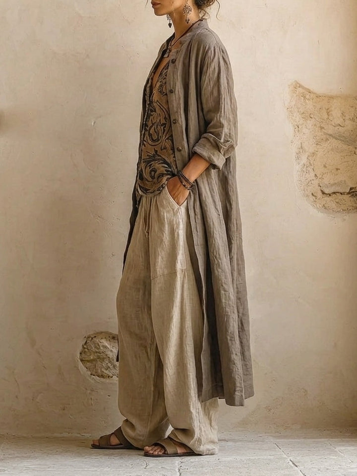 Vue de profil du long manteau ouvert aux manches retroussées, porté sur le top et le pantalon à poche 4