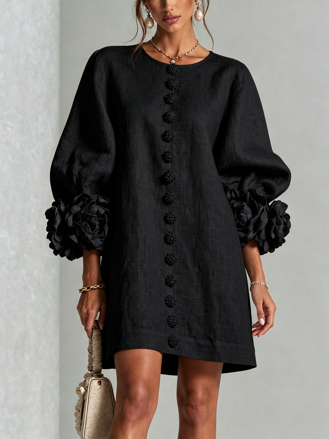 Robe noire portée de face, rangée de boutons fleurs au centre et fleurs aux poignets 4