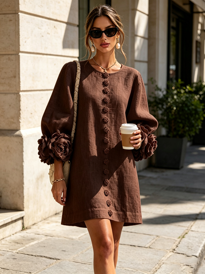 Robe marron portée en extérieur, rue ensoleillée, lunettes de soleil, gobelet en main, sac tressé à l'épaule. 34