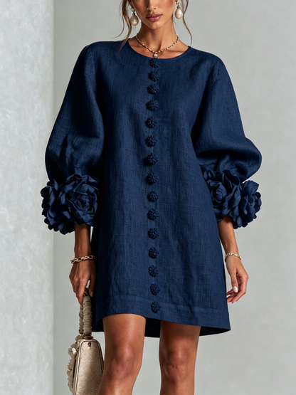 Robe bleu marine vue de face en studio, boutons fleurs alignés et grosses roses sur les manches. 12