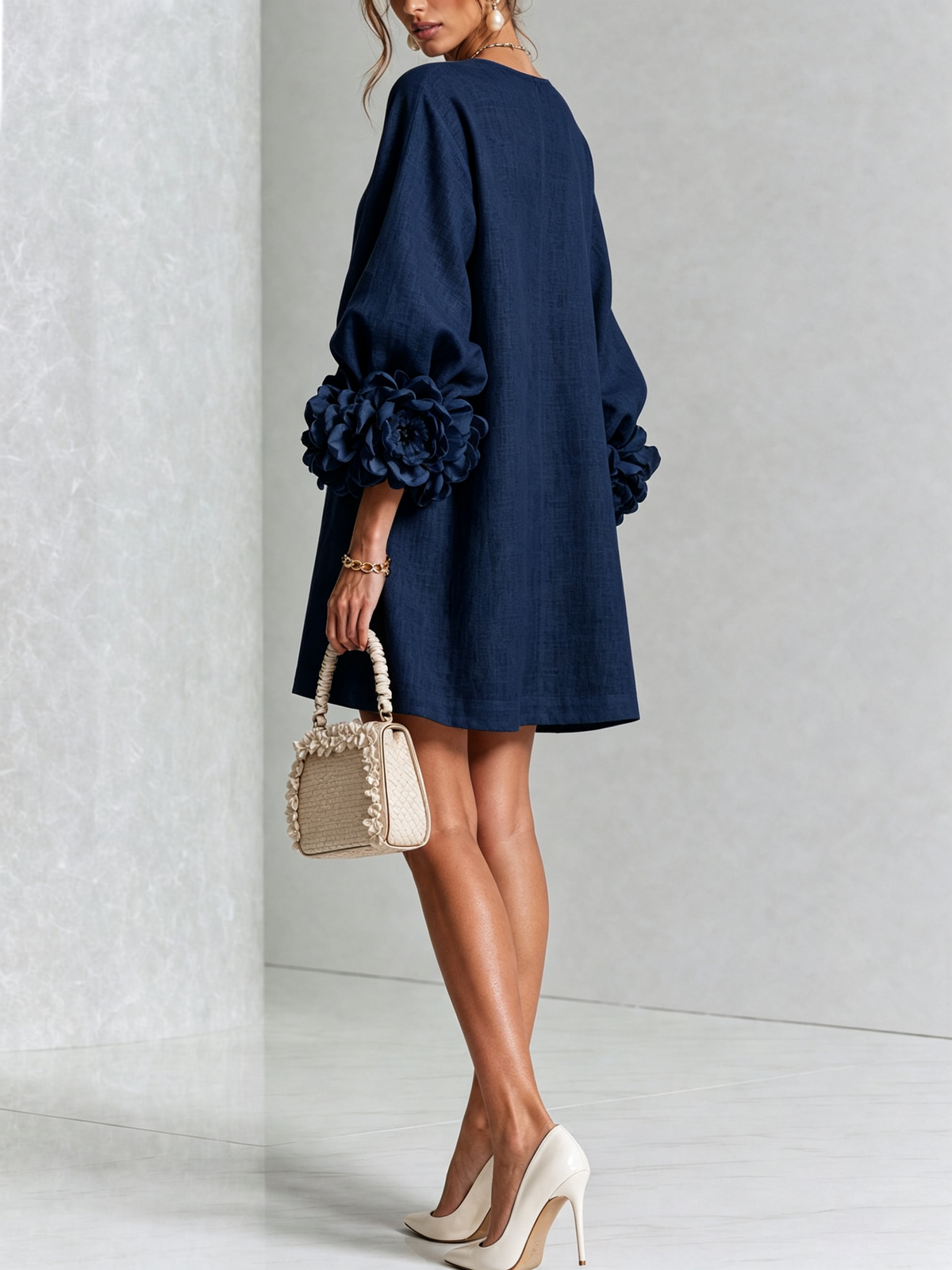 Robe bleu marine vue de dos en studio, dos uni et roses volumineuses aux poignets des manches. 20