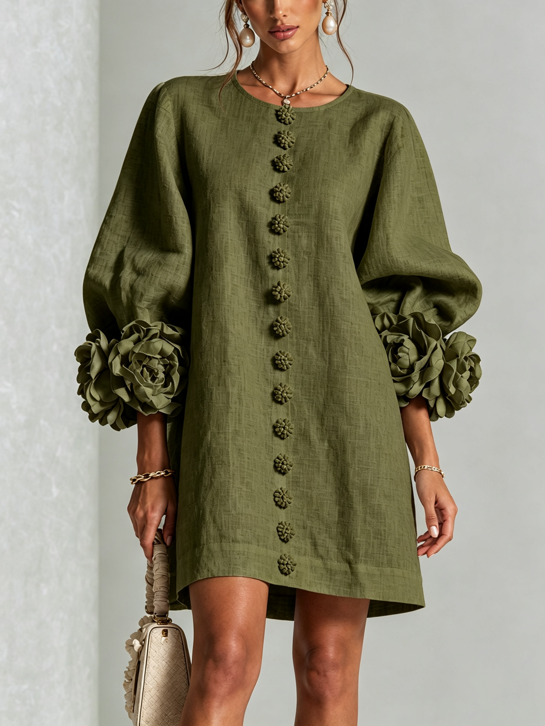 Robe vert olive vue de face en studio, rangée de boutons fleurs au centre et roses aux poignets des manches ballon. 11