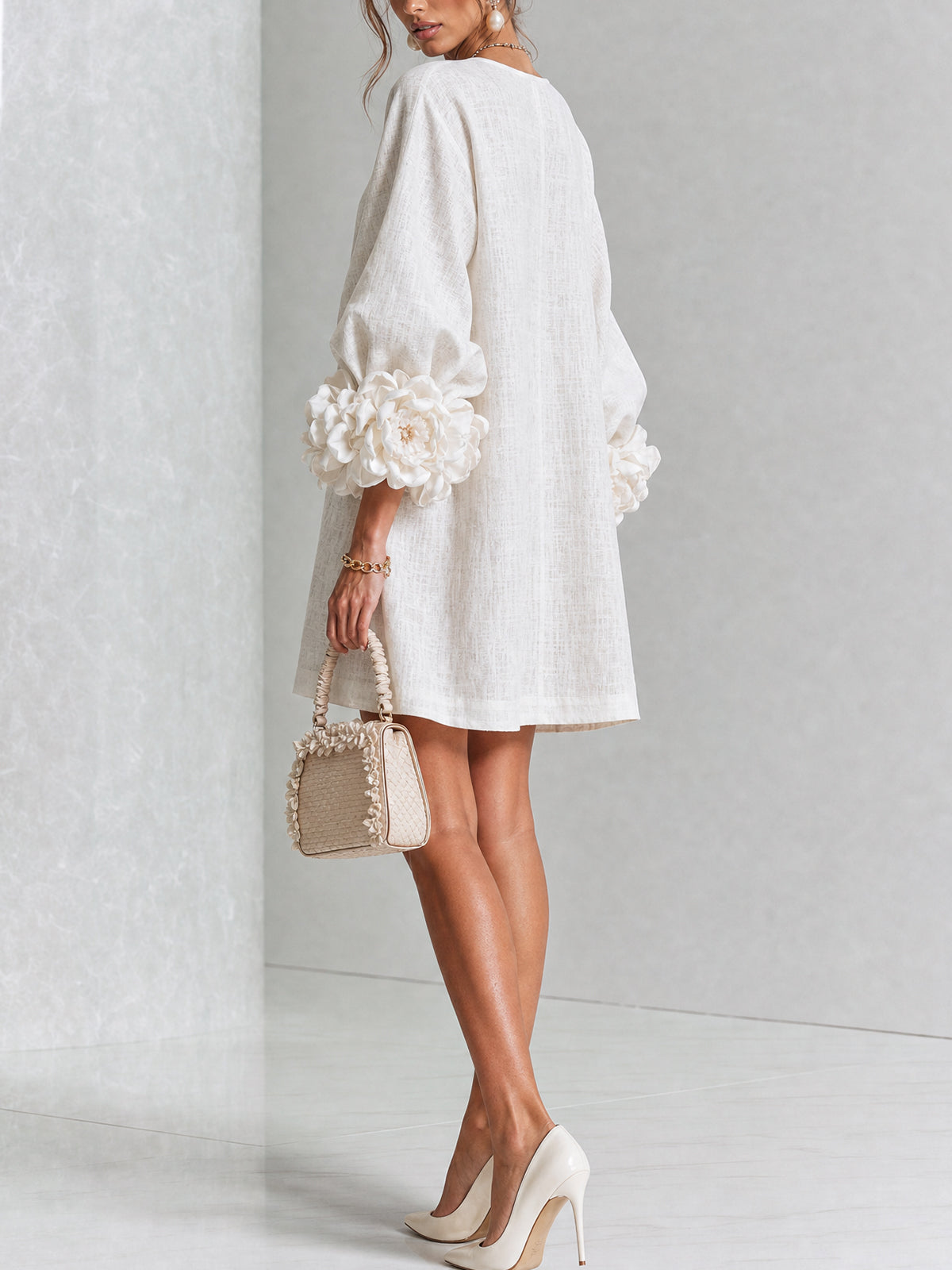 Robe écrue vue de dos et de trois quarts en studio, dos uni et roses aux poignets des manches ballon. 14