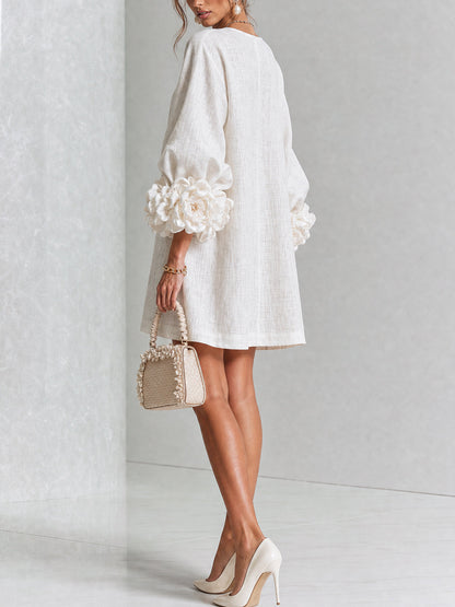 Robe écrue vue de dos et de trois quarts en studio, dos uni et roses aux poignets des manches ballon. 14