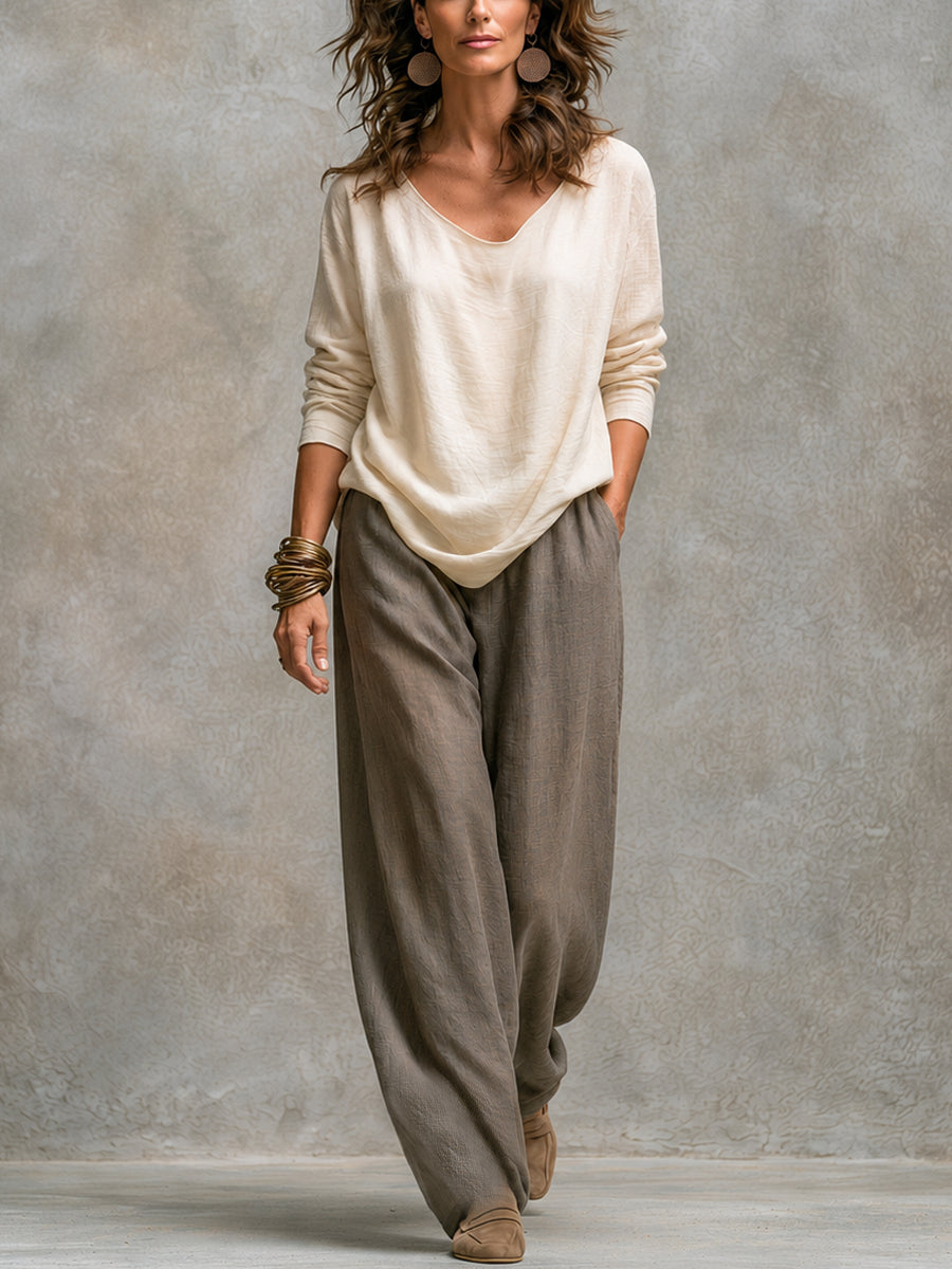 Femme de face portant seulement le haut crème à encolure en V et le pantalon large taupe, sans la veste. 2