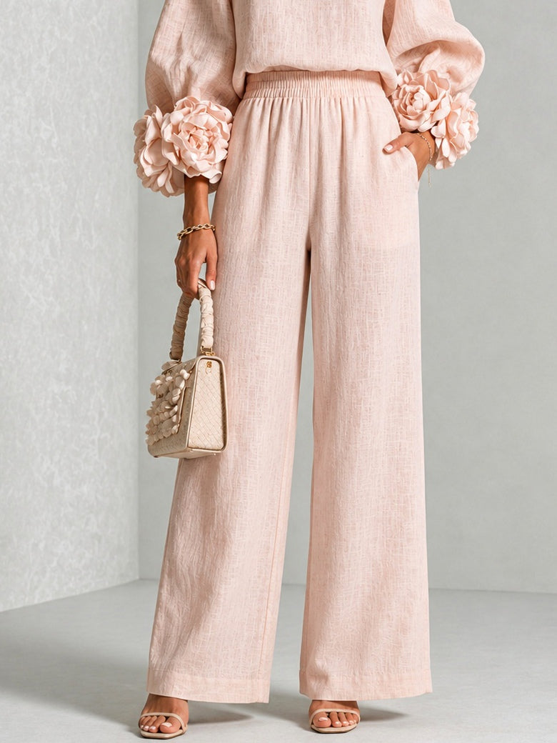 Gros plan sur le pantalon large rose pâle à taille élastique, avec poches et fleurs aux manches 11