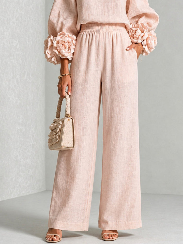 Gros plan sur le pantalon large rose pâle à taille élastique, avec poches et fleurs aux manches 11