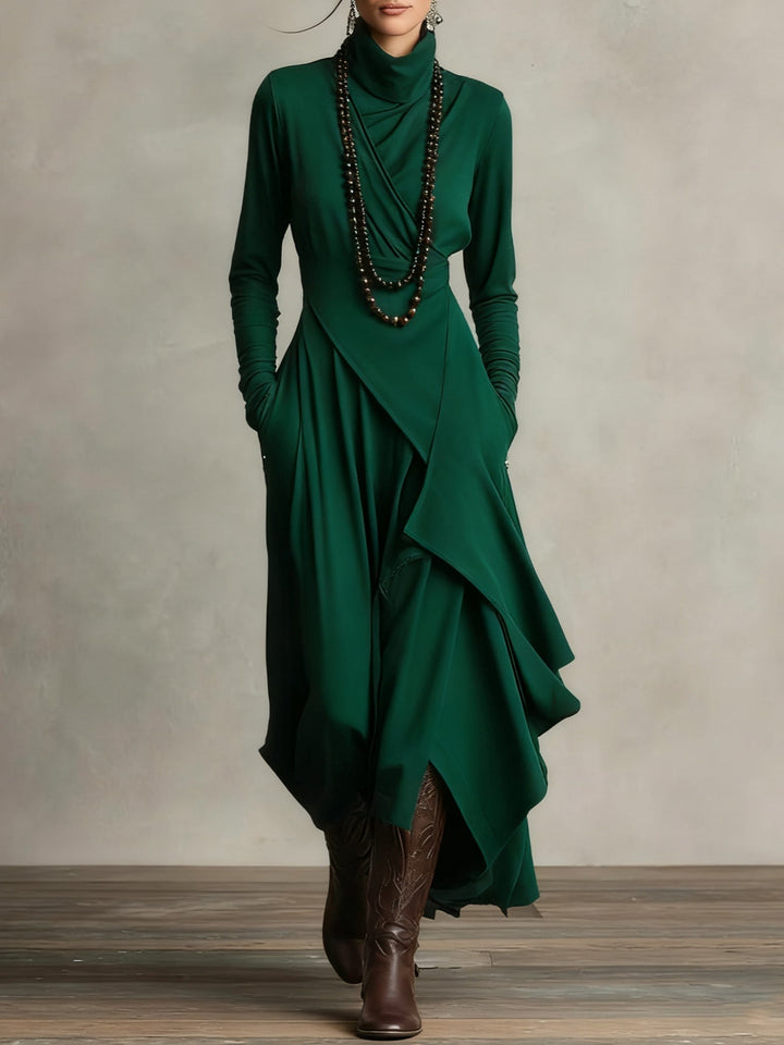 Robe vert foncé portée de face, avec col roulé drapé, collier de perles et bottes 11