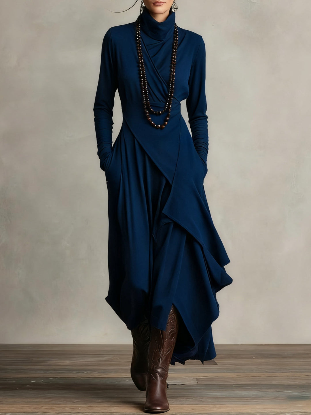 Robe bleu marine portée de face, avec col roulé drapé, collier de perles et bottes 10