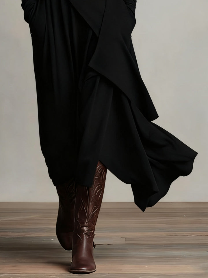 Détail du bas asymétrique de la robe noire, jupe fluide et bottes brunes gravées 8