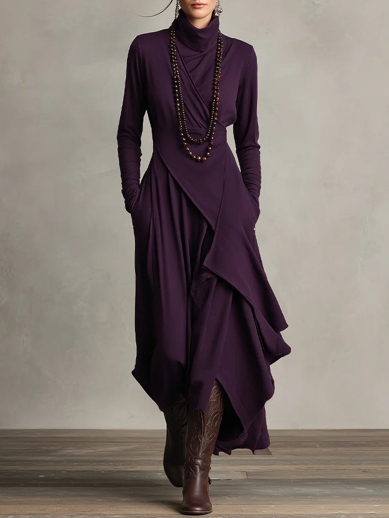 Femme portant la robe violet foncé de face, avec long collier de perles et bottes brunes 1