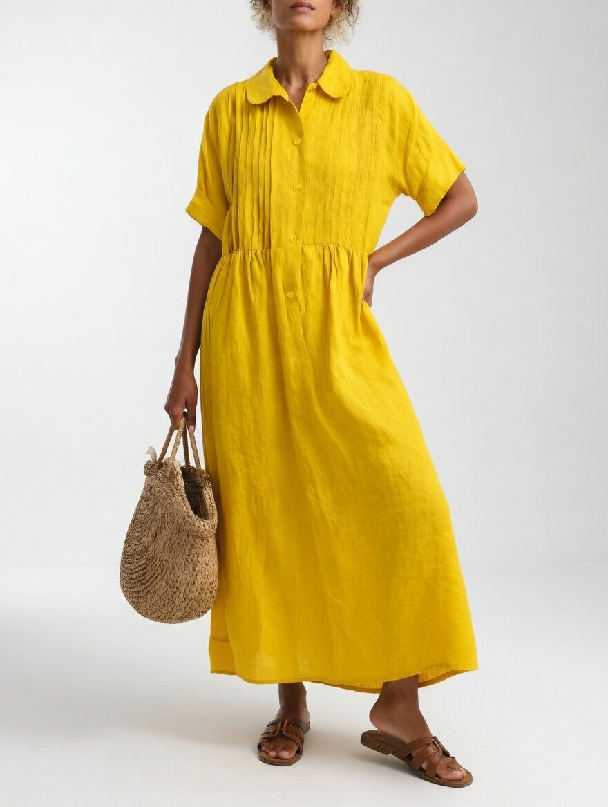 Robe jaune portée par une femme, une main sur la hanche, panier en paille à la main, vue de face. 6