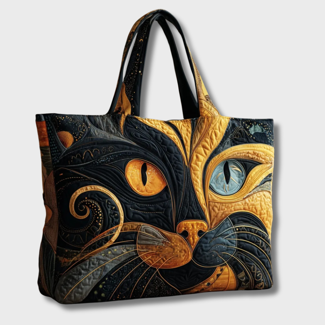 Sac matelassé au grand visage de chat stylisé, vu de trois quarts sur fond clair 2