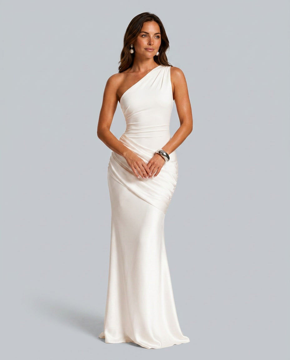 Robe blanc ivoire portée de face, avec boucles d'oreilles perles et bracelet argenté, épaule asymétrique et drapé sur la hanche. 3