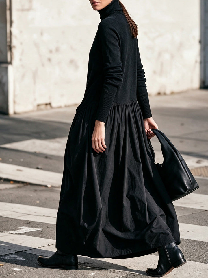 Robe noire vue de profil en marchant, manches côtelées et jupe ample, sac noir à la main 2