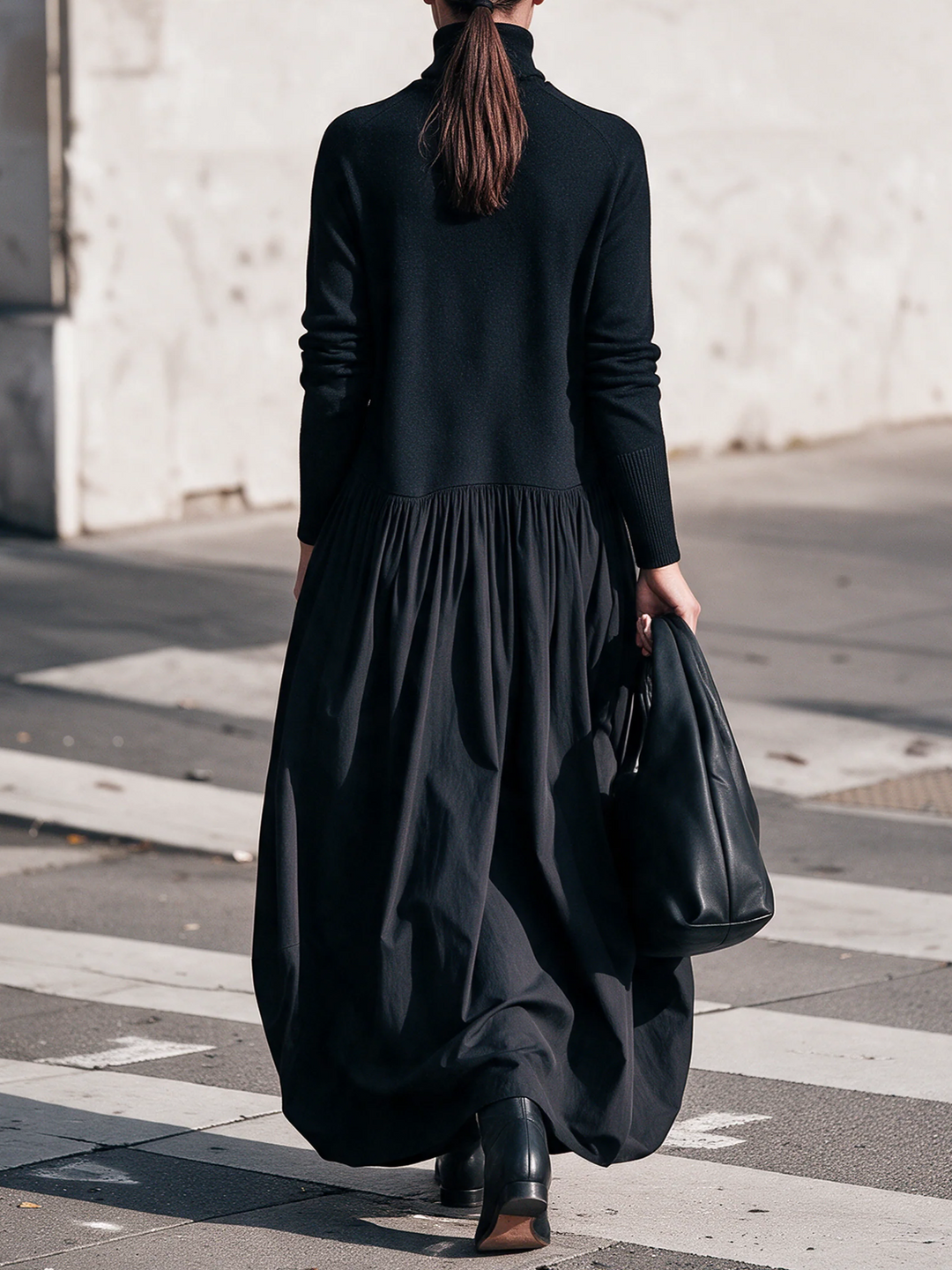 Robe noire vue de dos, avec la jupe froncée qui tombe et les manches longues 3