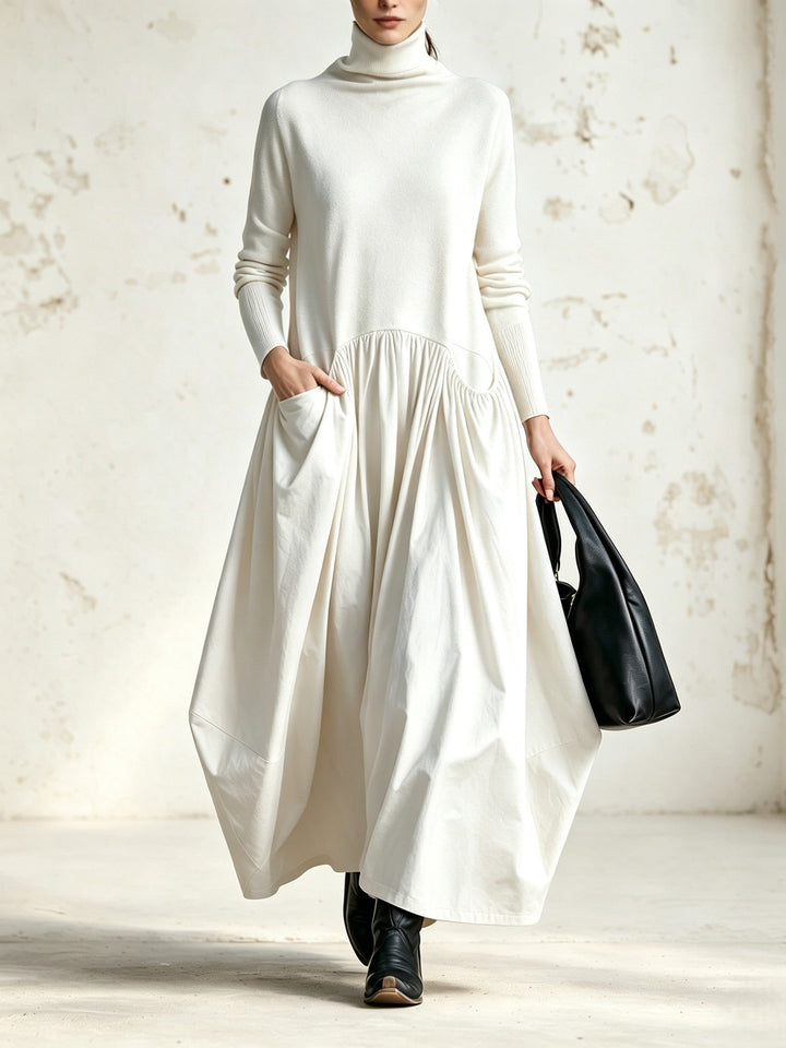 Robe blanc crème portée de face, col montant, jupe ample plissée, bottes et sac noirs 5