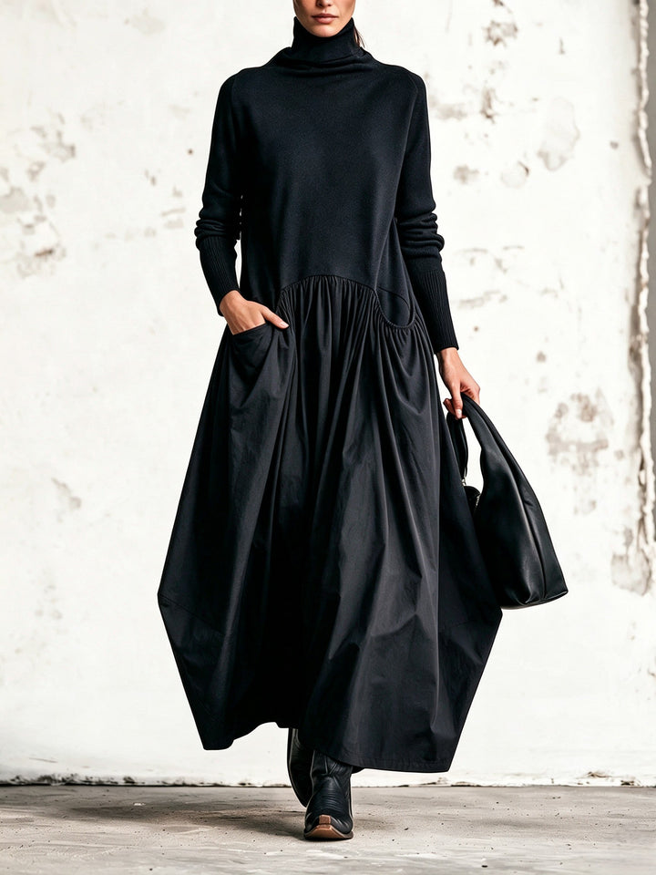 Robe noire portée de face, haut en maille, jupe ample plissée, main dans la poche 1