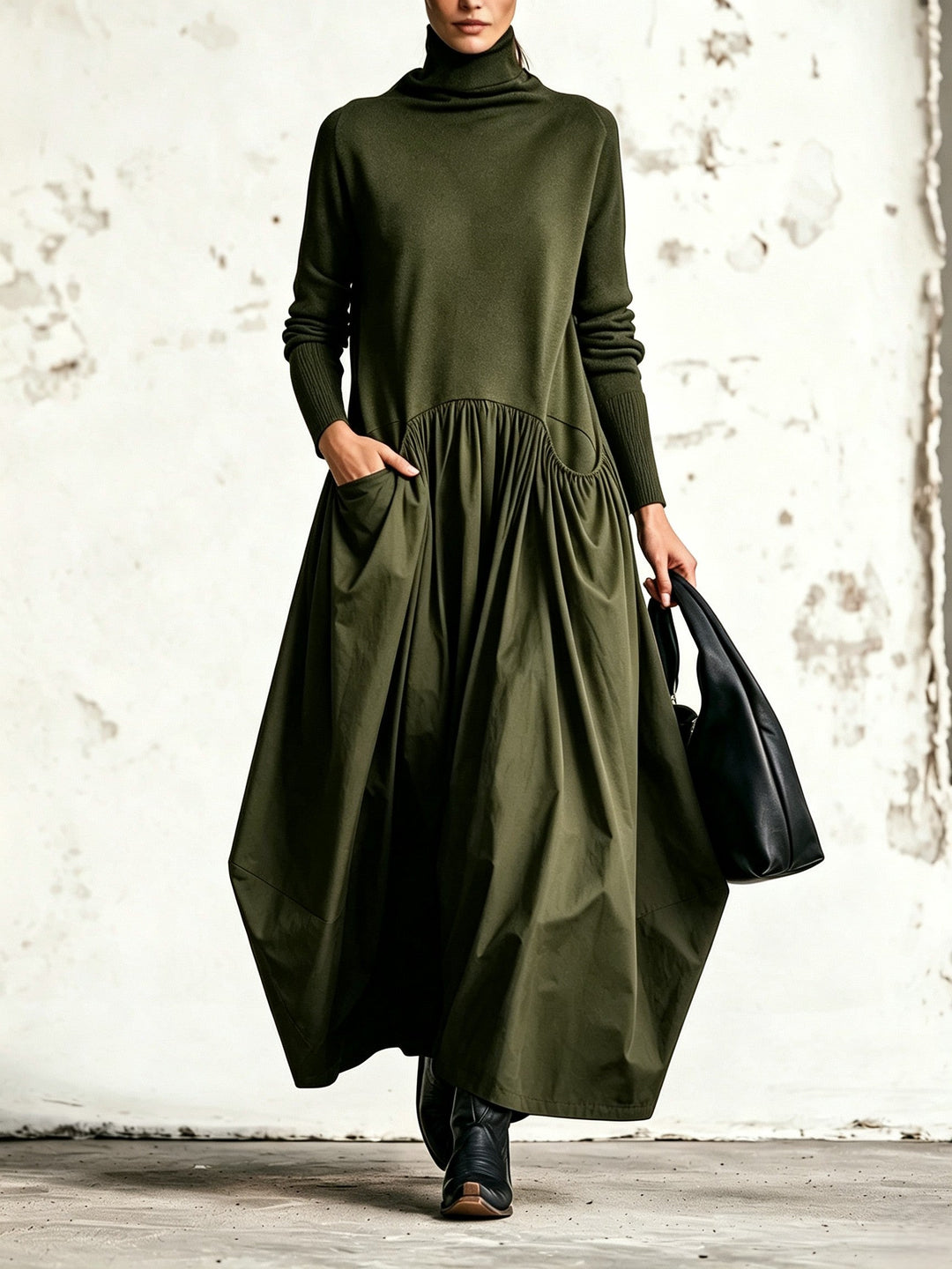 Robe vert olive portée de face, col montant, jupe ample plissée et main dans la poche 4