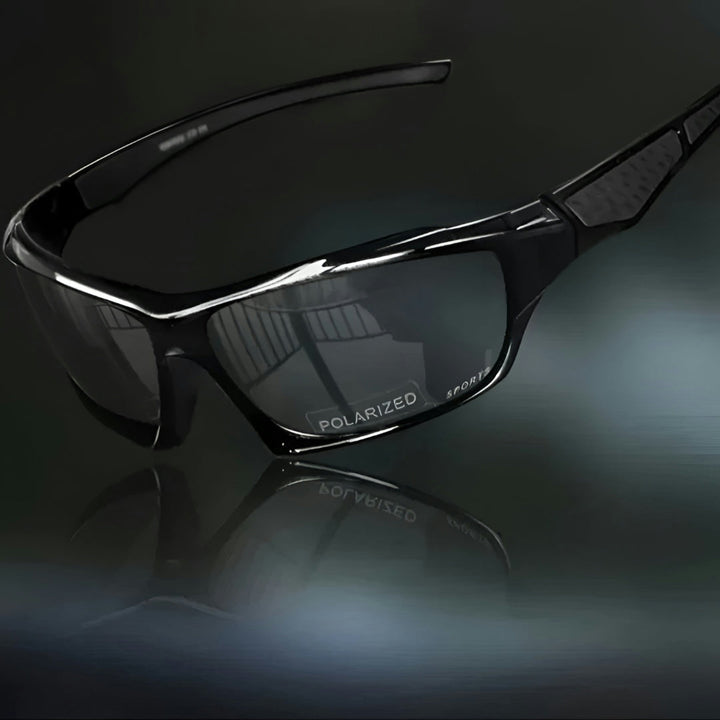 Vue de trois quarts des lunettes entièrement noires à verres gris foncé, sur fond sombre 10