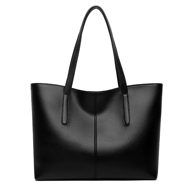 Sac cabas noir vu de face sur fond blanc, avec couture verticale centrale et longues anses 1