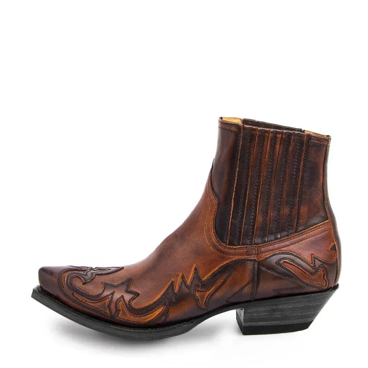 Bottine western en cuir brun cuivré vue de profil, bout pointu, motifs décoratifs cousus et semelle noire à talon incliné. 2