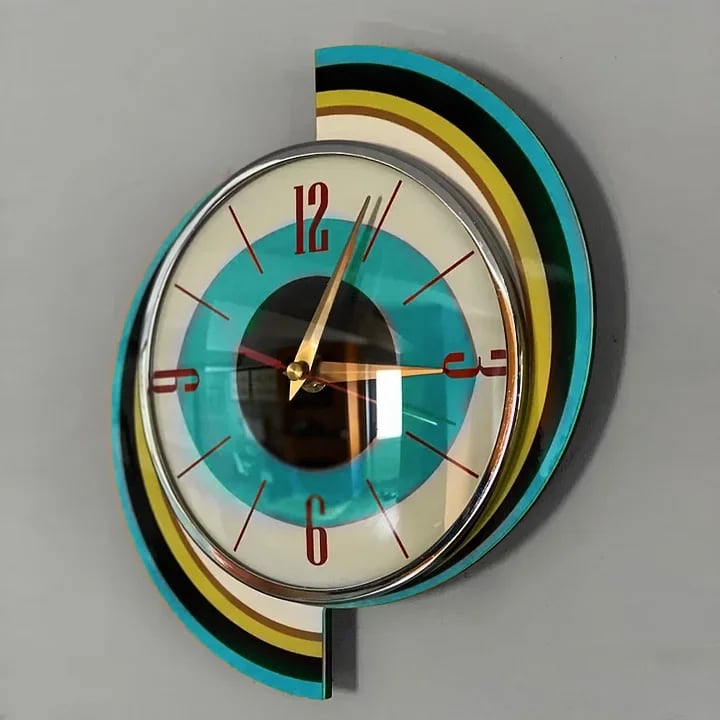 Horloge spirale vue de côté, montrant le relief du cadran bombé à bordure chromée devant les arcs colorés. 9