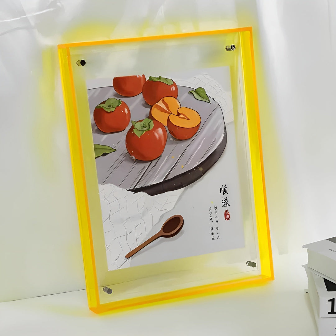 Cadre acrylique à bords jaune fluo avec halo lumineux, présentant une illustration de kakis et d'une cuillère en bois sur fond gris. 12