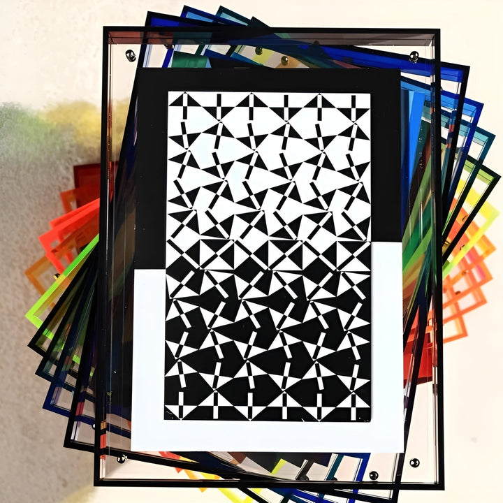 Pile de cadres acryliques de couleurs variées en éventail, celui du dessus à bords noirs avec un motif géométrique noir et blanc. 8