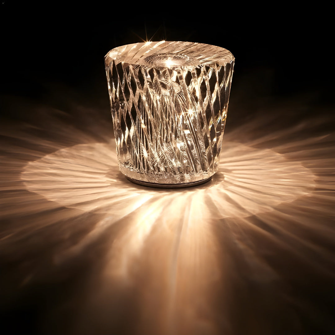 Lampe en cristal à facettes losangées allumée dans l'obscurité, entourée d'un large halo de rayons lumineux dorés. 17