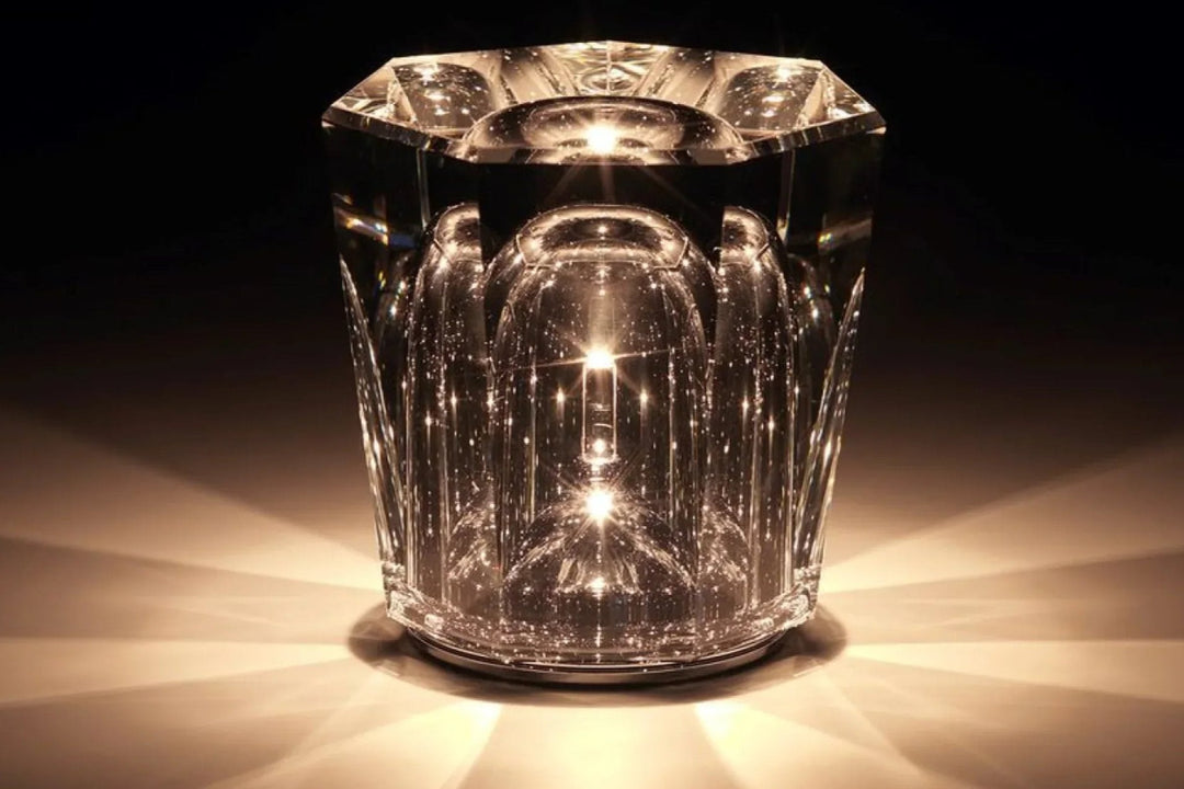 Lampe en cristal octogonale allumée sur fond noir, éclairant en étoile avec une lumière chaude et de petites bulles brillantes. 8