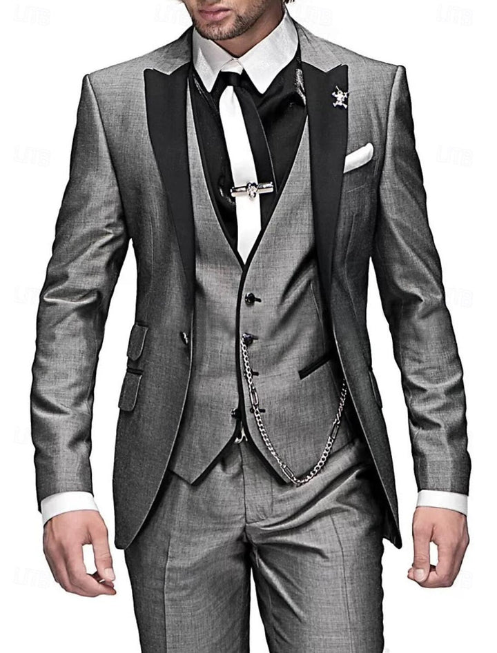 Costume trois pièces gris chiné à revers noirs, gilet avec chaîne, chemise noire, cravate blanche et pince à cravate argentée. 3