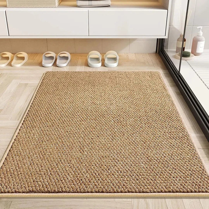 Tapis couleur caramel à bordure beige posé sur un parquet clair devant une douche, avec des sandales alignées 6