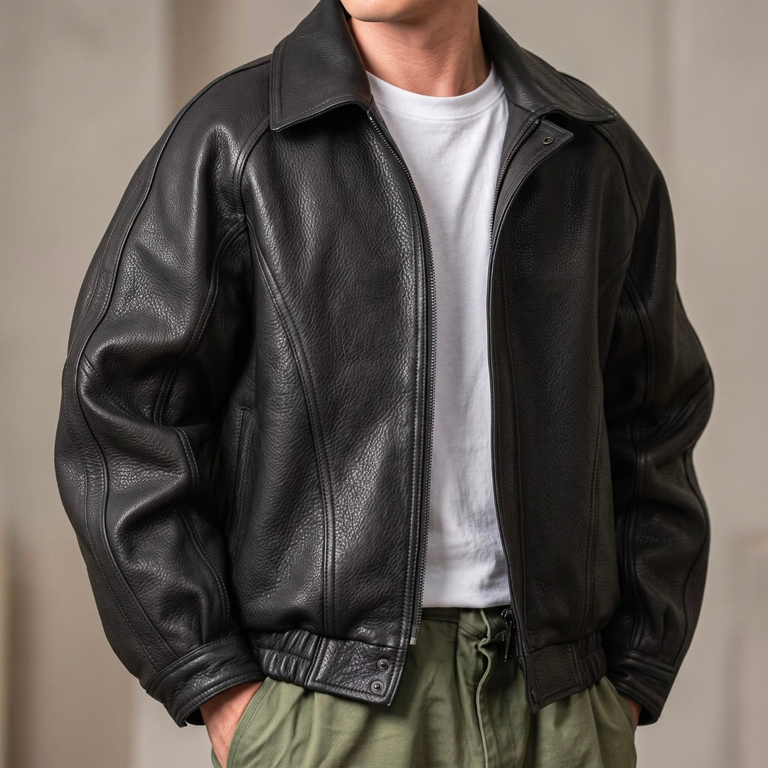 Homme portant la veste noire grainée ouverte sur un t-shirt blanc, vue de face, mains dans les poches d'un pantalon kaki. 1