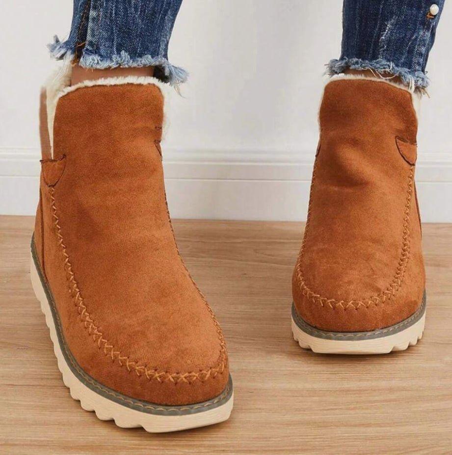 Bottines camel vues de face, portées avec un jean effiloché, avec surpiqûres décoratives sur le bout et col doublé de fourrure. 5