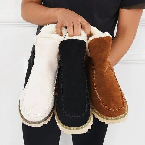Trois paires de bottines tenues ensemble dans les mains d'une personne : beige, noire et camel, toutes doublées de fourrure claire. 7