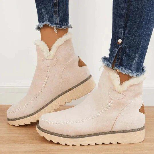Bottines beige clair portées de côté avec un jean effiloché, montrant la doublure duveteuse et la semelle crantée beige. 3