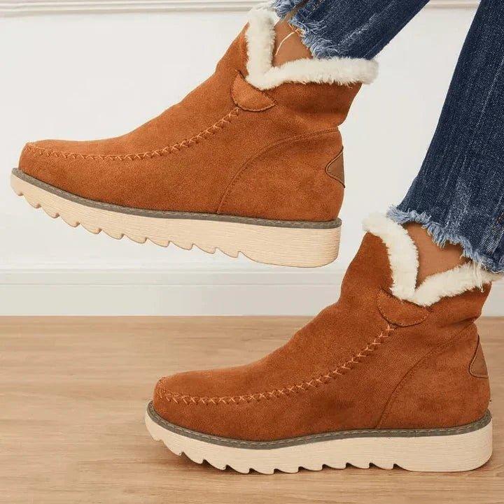 Bottines camel en suédine à surpiqûres, bord doublé de fourrure blanche, portées de profil avec un jean aux bords effilochés. 2