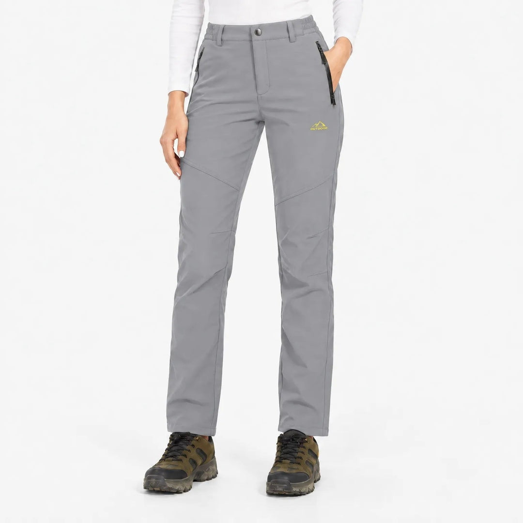 Pantalon gris clair porté de face par une mannequin avec haut blanc et chaussures de randonnée 9