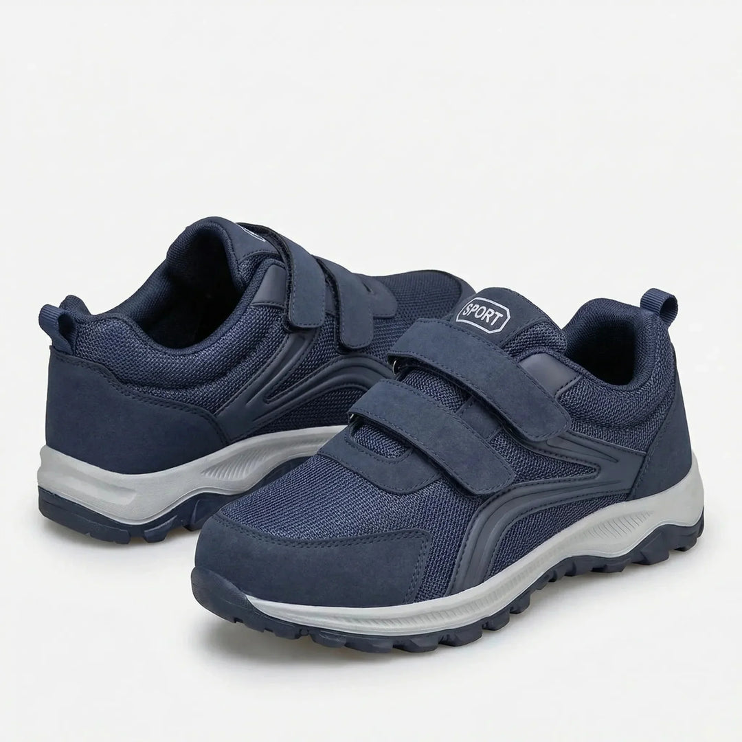 Paire de chaussures bleu marine à double scratch, l'une vue de l'arrière, semelle grise 9