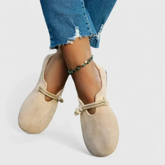 Mocassins beiges portés pieds croisés, avec cordon torsadé sur le cou-de-pied et jean retroussé 3