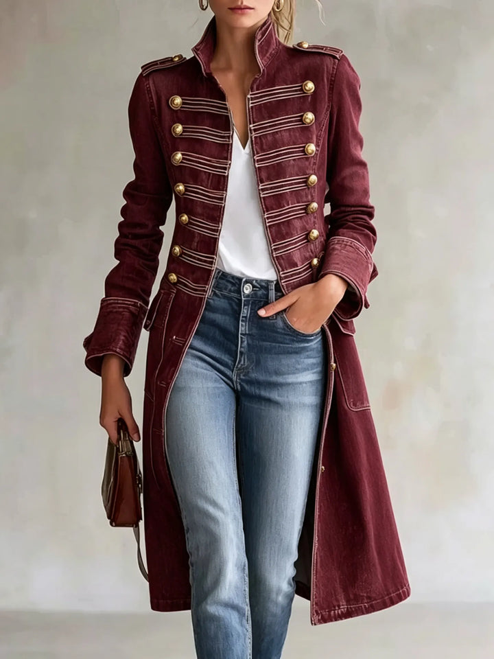 Manteau croisé à col officier en coloris bordeaux, boutons dorés et galons rosés, porté avec jean bleu clair et tee-shirt blanc. 11