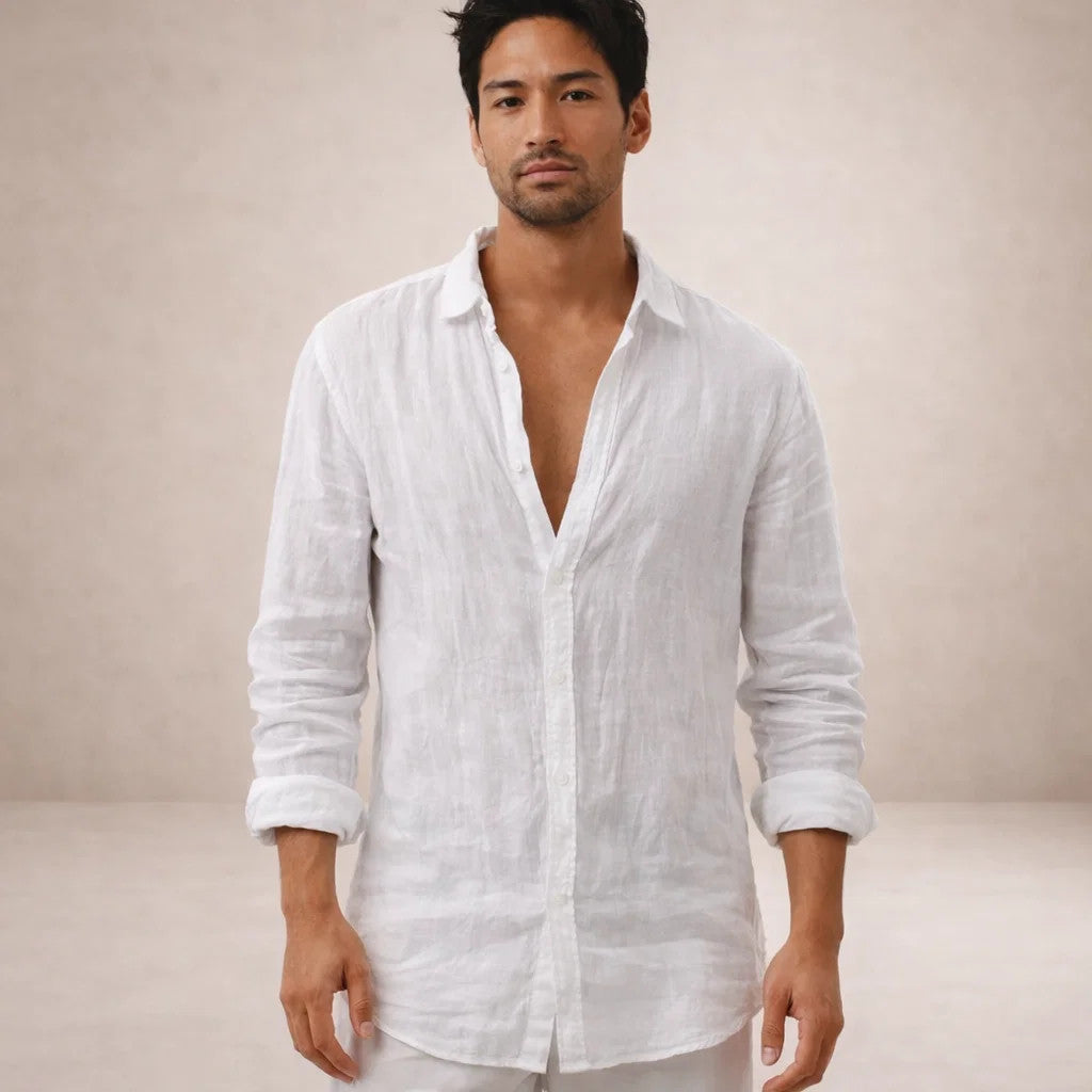 Homme en chemise en lin blanche et pantalon blanc, vue de face, col ouvert, manches retroussées, regard vers l'objectif. 9