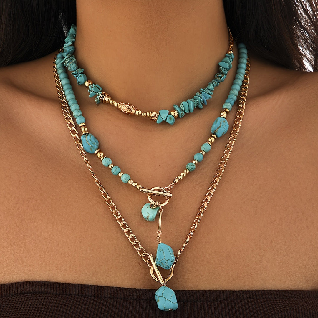 Trois colliers superposés en turquoise et chaînes dorées portés par un modèle, vue de face rapprochée 6