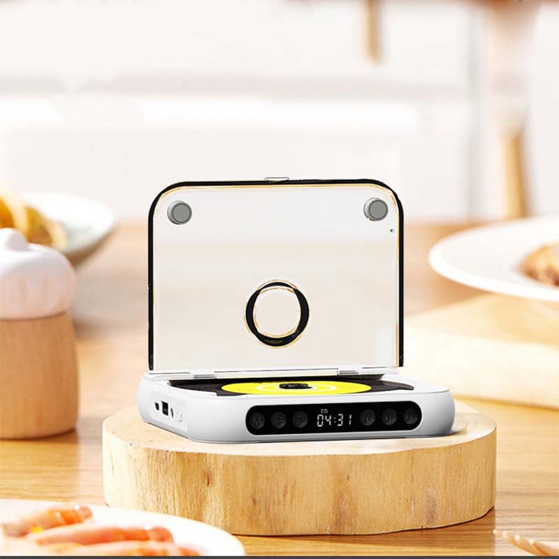 Lecteur blanc ouvert, vu de face avec le couvercle transparent relevé, posé sur un socle en bois dans une cuisine. 7