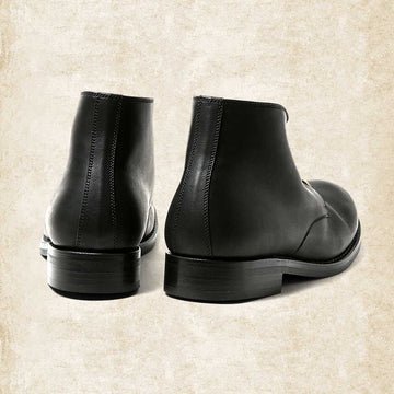 Bottines en cuir noir vues de dos, avec couture verticale au talon et semelle à talon bas. 5