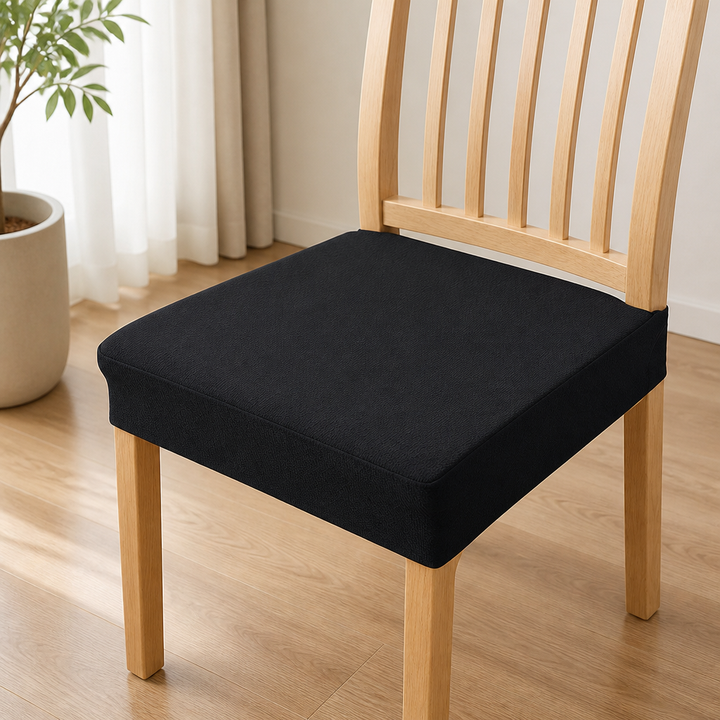 Housse d'assise noire unie et ajustĂ©e sur une chaise en bois clair Ă  barreaux, près d'une plante et d'un rideau. 13