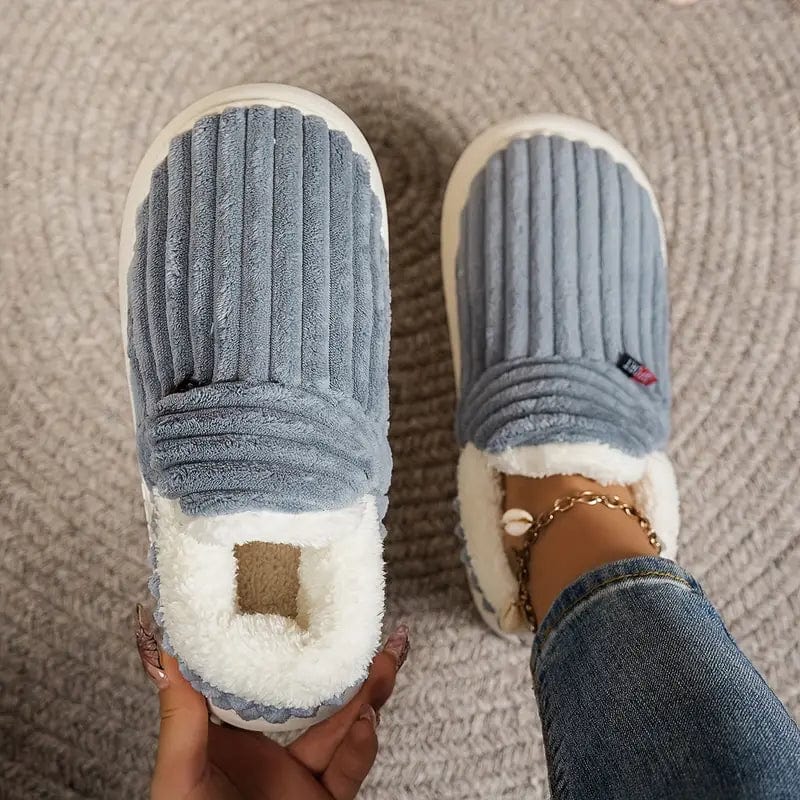 Chaussons gris-bleu côtelés vus de dessus sur un tapis, l'un tenu en main, l'autre porté avec un jean. 7