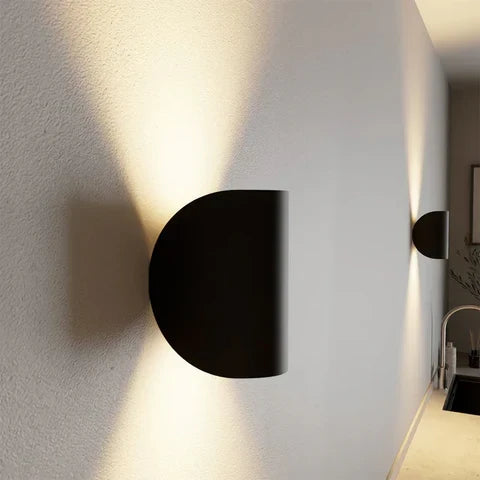 Vue de côté d'une applique noire en demi-disque fixée au mur, avec faisceaux lumineux vers le haut et le bas. 8
