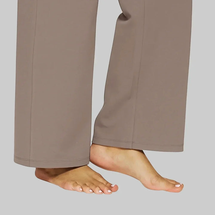 Détail du bas des jambes droites du pantalon taupe, avec surpiqûres de l'ourlet, porté pieds nus. 5